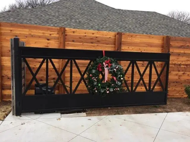 Custom black horizontal driveway gate set against cedar board-on-board fence
